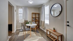 Ein gemütlicher Wohnbereich mit Essplatz, einer kleinen Bücherei und einem Spiegel an der Wand.