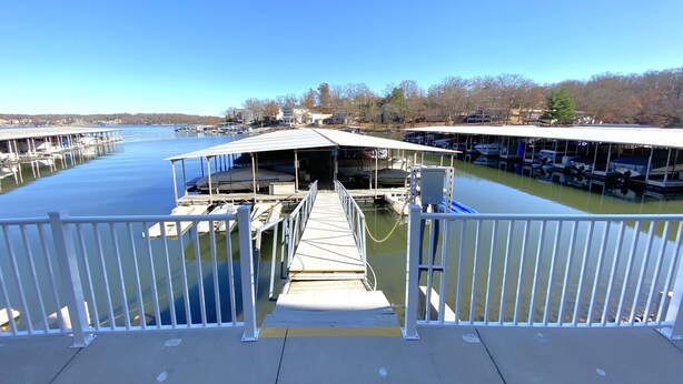 A dock extending into a calm body of water with boats moored at the dock. - Lakefront Corner Condo with Boat Slip - Stunning Views - Pool - Laundry (Osage Beach)