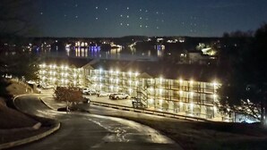 A hotel with multiple floors, outdoor lighting, and a parking area. - Lakefront Corner Condo with Boat Slip - Stunning Views - Pool - Laundry (Osage Beach)