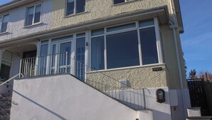 Un edificio de varios pisos con balcón, ventanas grandes y una escalera.