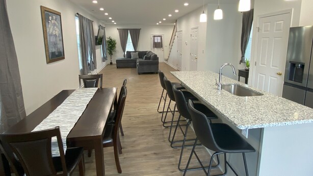 Eine moderne Küche mit einer Granitabdeckung, Edelstahlgeräten und einem Essbereich mit einem Holztisch und Stühlen.