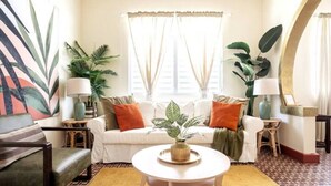 Sala de estar com sofá, mesa de centro e plantas em vasos.