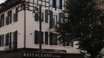 A two-story building with a restaurant named "RESTAURANT La Cozna" on the ground floor.
