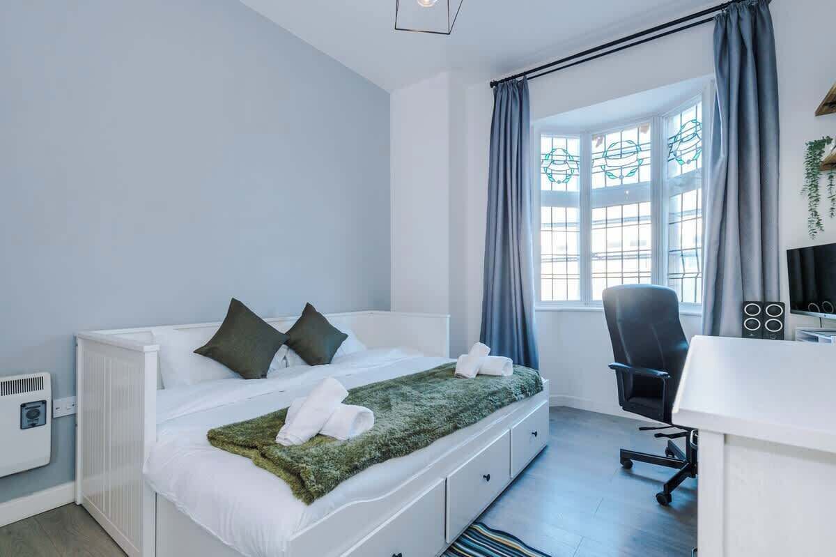 Ein modernes Schlafzimmer mit Bett, Schreibtisch und Stuhl.