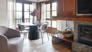 A cozy room with a round table, chairs, a fireplace, and large windows. - Val de Ruda Luxe 10 by FeelFree Rentals (Baqueira)