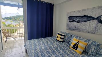 Un dormitorio con una cama, vistas al exterior y una lámpara en el techo.