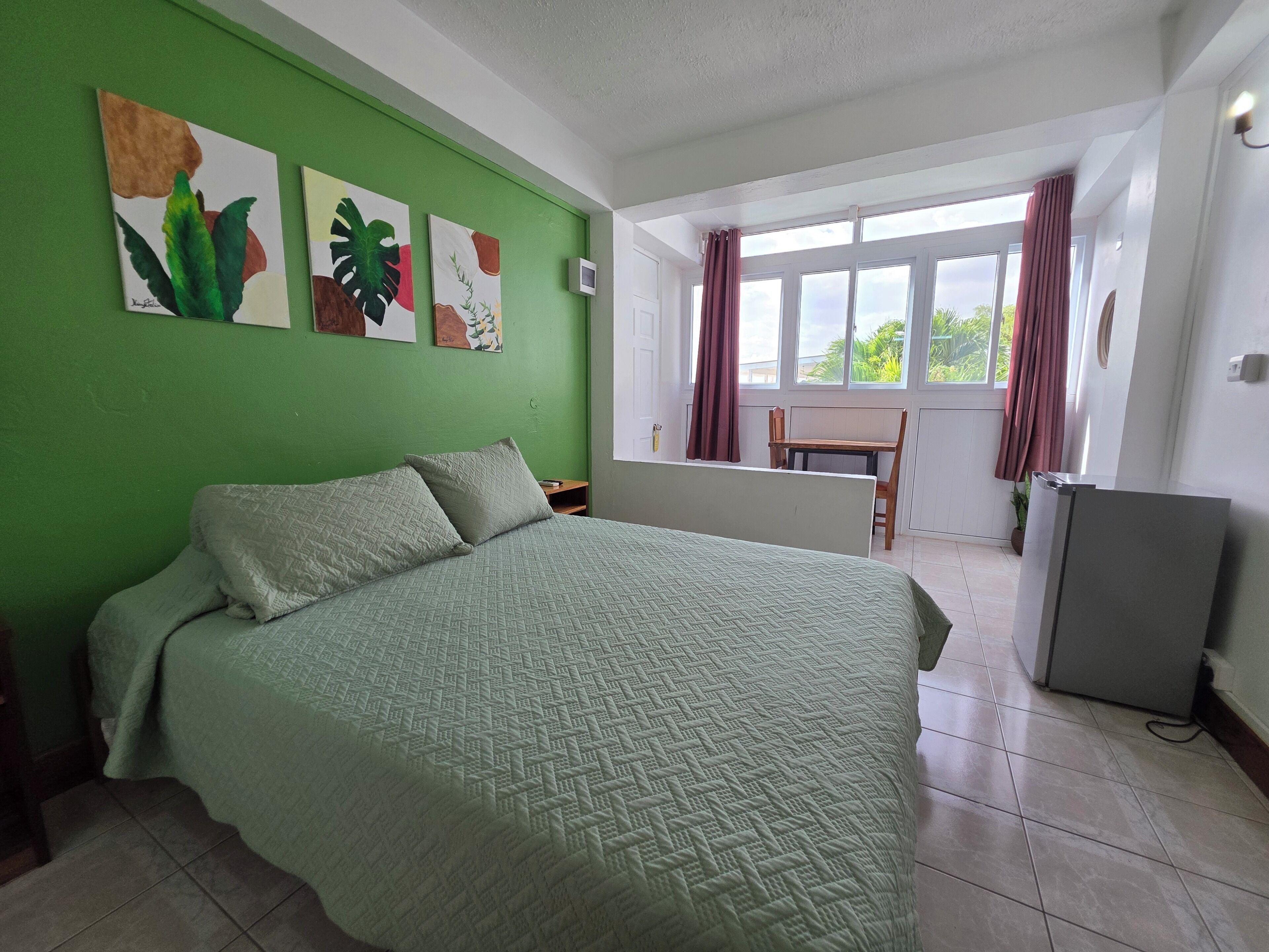 Une chambre avec un lit, un bureau et une fenêtre avec des rideaux.