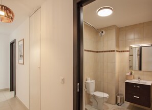 A modern bathroom with a toilet, shower, and sink. - Appartement "Fiora" en centre-ville de Calvi - 2 4 personnes (Calvi)