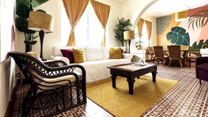 A living room with a sofa, chairs, a coffee table, and a dining area with chairs and a table. - 610@Miramar- up to 40 people (San Juan)