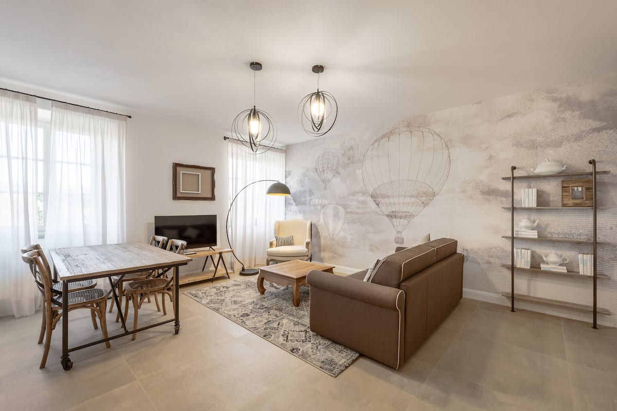 Ein modernes Wohnzimmer mit Esstisch, Sofa und Fernseher.