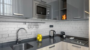 Eine moderne Küche mit Spüle aus Edelstahl, einer Mikrowelle und einem Wasserkocher.