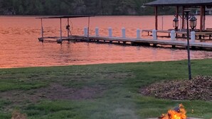 Una terrazza sul lago con un braciere e un pontile che si protende nell'acqua.