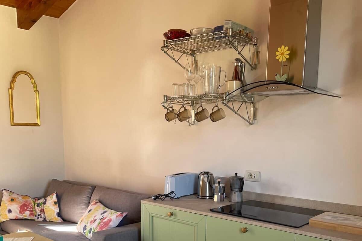 Cuina compacta amb taulell verd, cafetera i torradora.