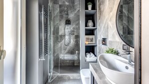 A modern bathroom with a glass-enclosed shower, a large sink, and marble walls. - NEW COZY TERRACE VATICAN APT. (Roma)