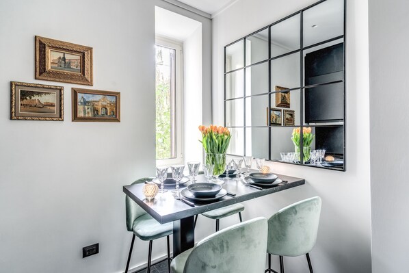 A dining area with a long table, chairs, and framed pictures on the wall. - NEW, COZY APARTMENT WITH A TERRACE NEAR THE VATICAN (Roma)