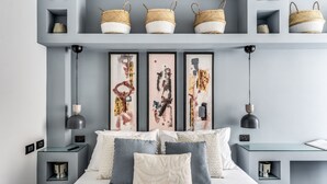 A modern bedroom with a bed, bedside tables, a desk, and decorative baskets on shelves. - NEW COZY TERRACE VATICAN APT. (Roma)