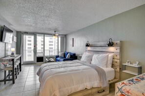 Um quarto moderno com uma cama grande, uma escrivaninha e um sofá.