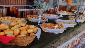 A buffet with various breads and pastries displayed in baskets. - HotFérias Flat Enseada pesca permitida (Caldas Novas)