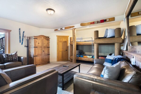 Une pièce chaleureuse avec un lit superposé, une armoire en bois, un canapé et une table basse.