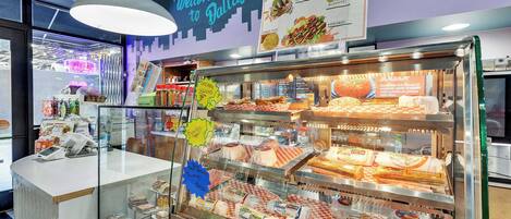 A food display case with various items like chicken, sausage, and bacon.