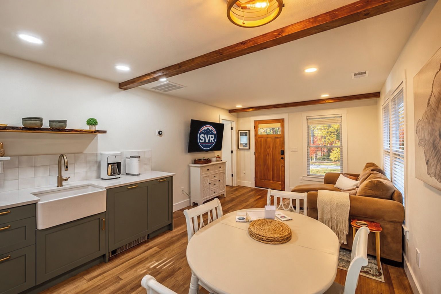 Un espace de vie compact comprenant une kitchenette, un coin repas et un coin salon.