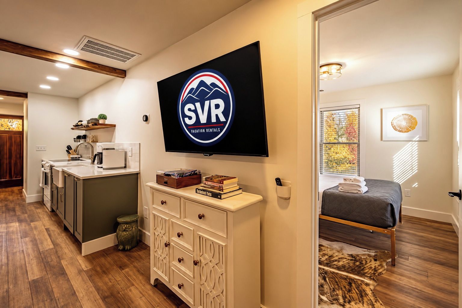 Ein modernes Interieur mit einer Küche, einem Wohnbereich mit einem Bett und einem angebrachten Fernseher, der das SVR-Logo zeigt.