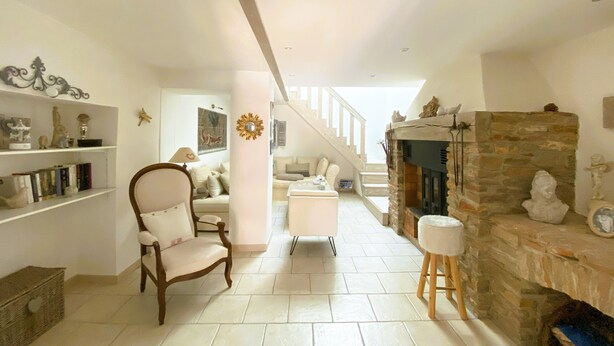 A spacious living room with a high ceiling, a fireplace, a staircase, and a cozy seating area. - Villa Provençale (La Cadière-d'Azur)