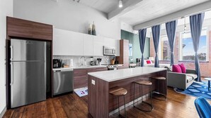 A modern kitchen with a central island, stainless steel appliances, and a cozy seating area with a view. - Amyfinehouse Loft with Breakfast, Valet, Gym (Dallas)