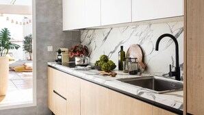 A modern kitchen with light wood cabinets, a marble backsplash, and a black faucet. - Penthouse with sea view  walking distance to the beach - EL SALTIO (Torremolinos)