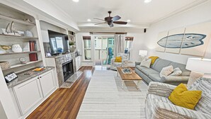 Un salon avec une cheminée, un canapé, une table basse et un ventilateur de plafond.