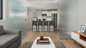 Ein modernes Wohnzimmer mit einem grauen Sofa, einem Couchtisch und einem Bücherregal.