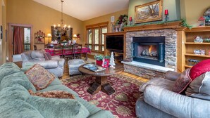 A cozy living room with a fireplace, leather sofas, a dining area, and a chandelier. - Spacious Holiday Retreat in Keystone! (Keystone)