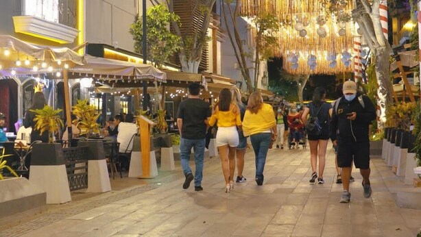 A bustling street with outdoor seating, potted plants, and hanging decorations. - Aparts4Days Miraflores Down Town 1 or 3 Bedroom Apartment (Lima)