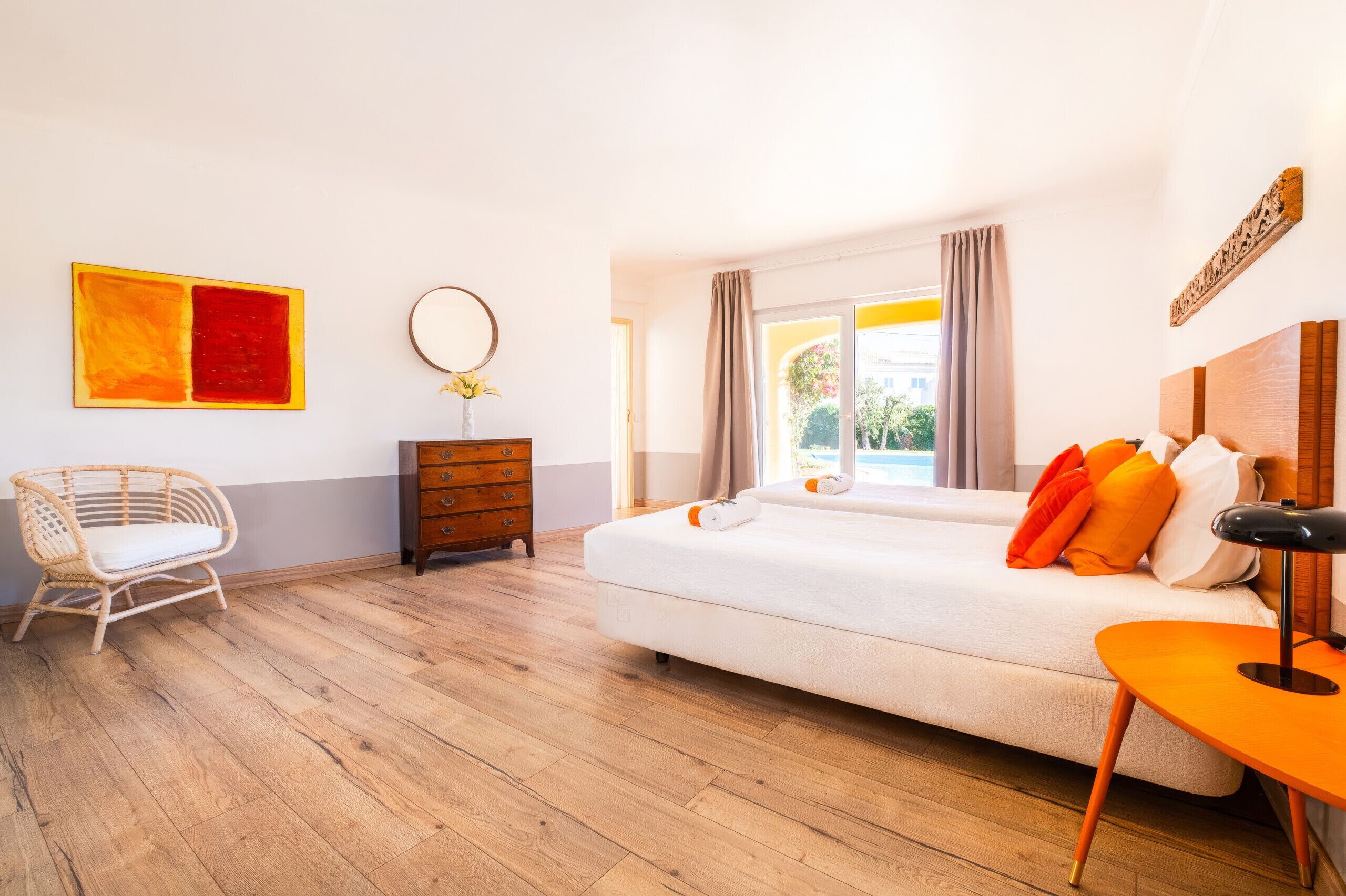 Hotellihuone, jossa on sänky, tuoli, lipasto ja työpöytä.