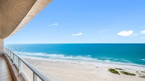 Ein Balkon mit Blick auf Strand und Meer.