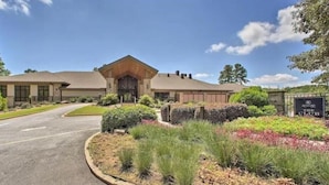 A two-story building with a central entrance, surrounded by landscaped gardens and a paved driveway.