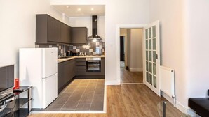 Una cocina moderna con armarios oscuros, un refrigerador blanco y un salpicadero de azulejos.