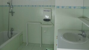 A bathroom with a bathtub, a shower, a toilet, and a sink.