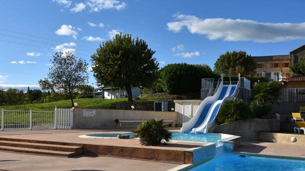 Une piscine avec un jacuzzi et un toboggan aquatique.