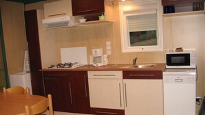 A compact kitchen with a gas stove, coffee maker, microwave, and dishwasher. - Chalet 3 people (MONTREAL)