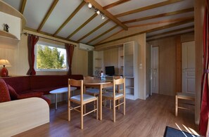 Relax in a cozy space with a sofa, dining table, and TV for entertainment.