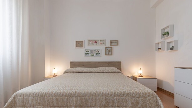 A bedroom with a bed, bedside tables, and wall art. - Italian Experience - Il Colle Sul Mare Holiday Home (Porto Recanati)