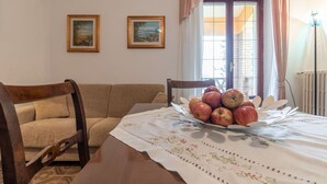 A dining area with a table set for two, a bowl of apples, and two framed pictures on the wall. - Italian Experience - Il Colle Sul Mare Holiday Home (Porto Recanati)