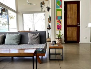 Ein modernes Wohnzimmer mit einer Couch, einem Couchtisch und einer Tür mit Bambusverkleidung.