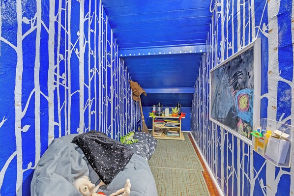 A room with a bed, a small table with items, and a painting on the wall.