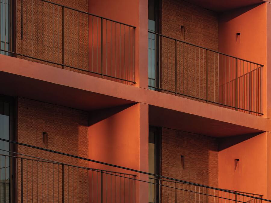 Un edificio de varios pisos con balcones y grandes ventanales.