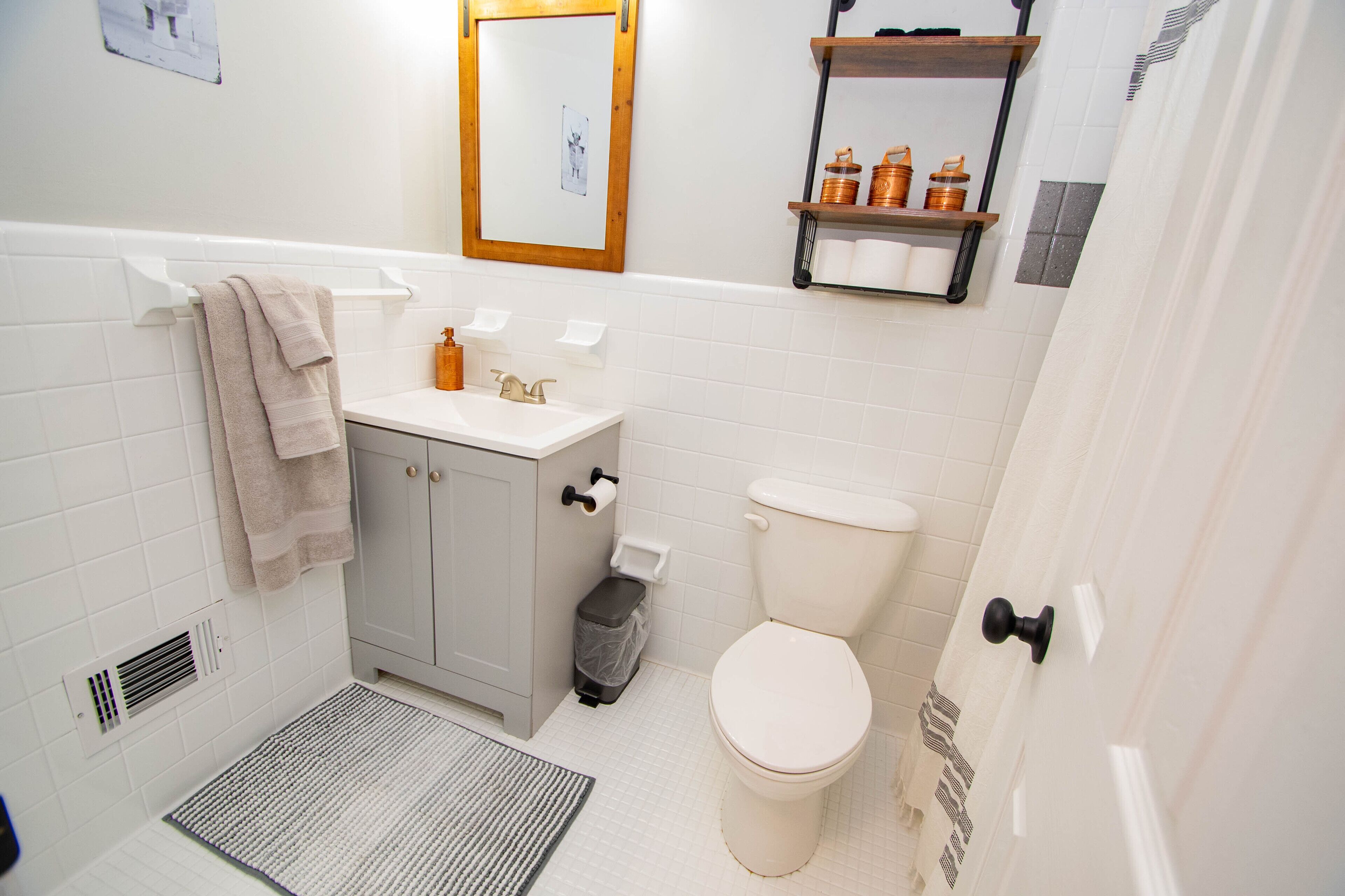 A bathroom with a toilet, sink, and shower area.