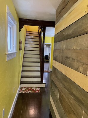 Un escalier en bois avec une rampe blanche menant à un palier.