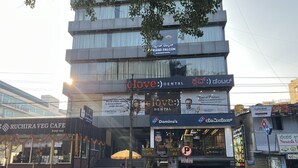 A multi-story building with a 'Grand Falcon Business Hotel' sign.