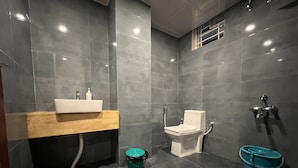 A modern bathroom with a sink, toilet, and shower.